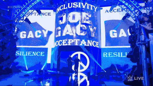 a sign that says joe gacy acceptance is on a stage