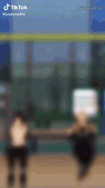 a blurred image of two people standing next to each other with a tiktok watermark