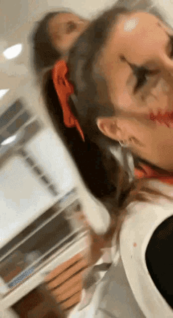a woman with blood on her face is standing next to another woman