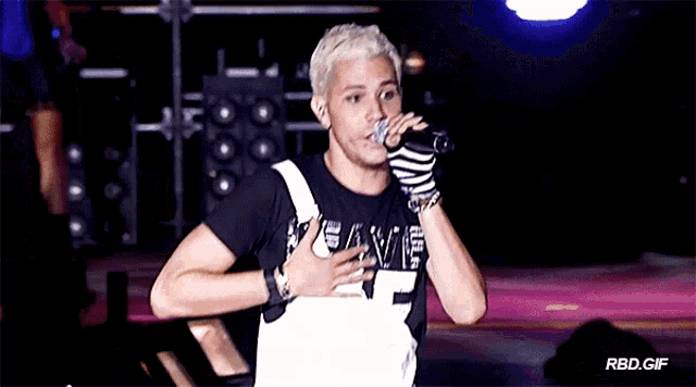 a man singing into a microphone while wearing a shirt that says fame 7