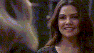 a close up of a woman 's face with a blurred background and a smile on her face .