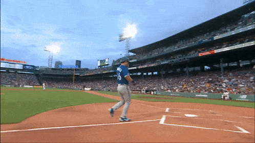 a baseball player with the number 18 on his jersey is running towards home plate