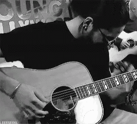 a man playing an acoustic guitar in a black and white photo