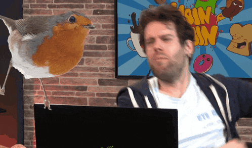 a man sits in front of a laptop with a cartoon behind him that says ' ssim ' on it