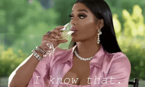 a woman in a pink shirt drinking a glass of wine with the words i know that behind her