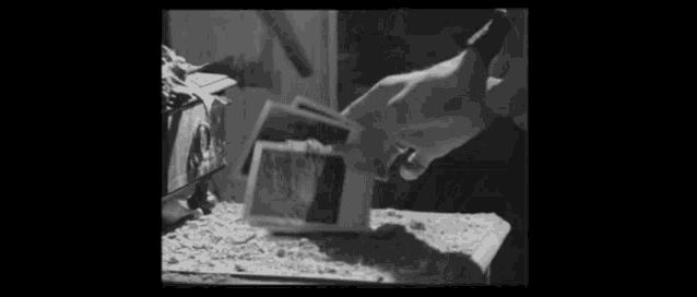 a black and white photo of a person cutting a piece of paper