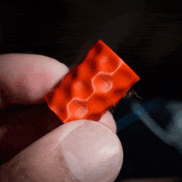 a person is holding a piece of red plastic