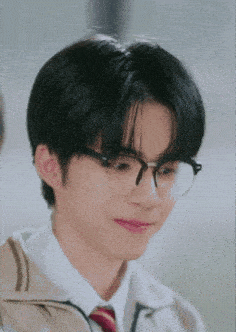 a young man wearing glasses and a tie is making a funny face