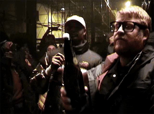 a man with glasses and a beard holds a microphone in a crowd