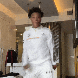 a man wearing a white adidas jacket is dancing