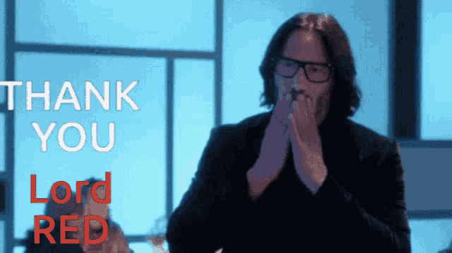 a man with glasses is clapping in front of a thank you lord red sign
