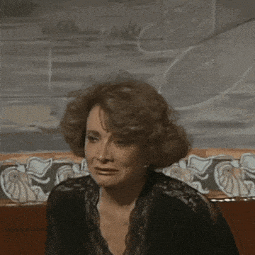 a woman is crying while holding her head with her hand