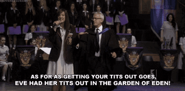 a man in a suit and tie shakes hands with a woman with long hair in front of a crowd