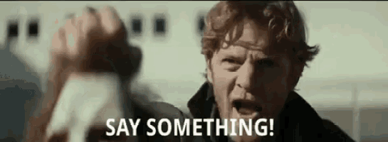 a man with red hair and a beard is yelling at another man .