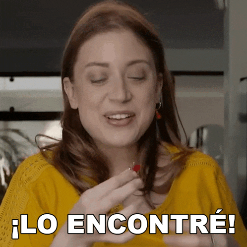 a woman in a yellow shirt is holding a small red object and says lo encontré