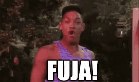 a man in a purple tank top is standing in front of a sign that says fuja .