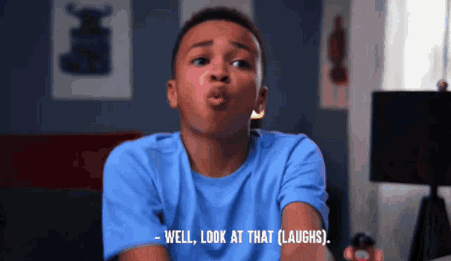 a boy in a blue shirt is saying well look at that laughs