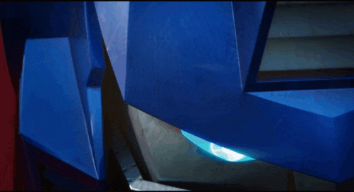 a close up of a blue robot 's head with a blue light coming out of it