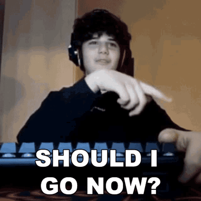 a boy is pointing at a keyboard with the words should i go now written on it
