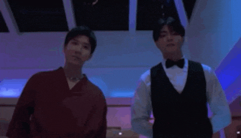two men are holding guns in a dark room .