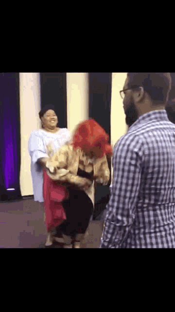 a man in a plaid shirt is standing next to a woman in a red dress