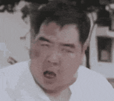 a close up of a man making a funny face with his mouth open .