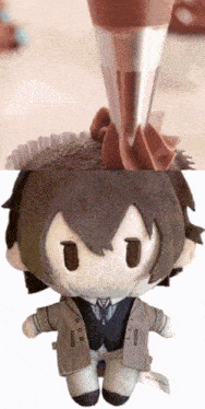 a stuffed doll is being decorated with chocolate frosting and a cupcake is being decorated with chocolate frosting
