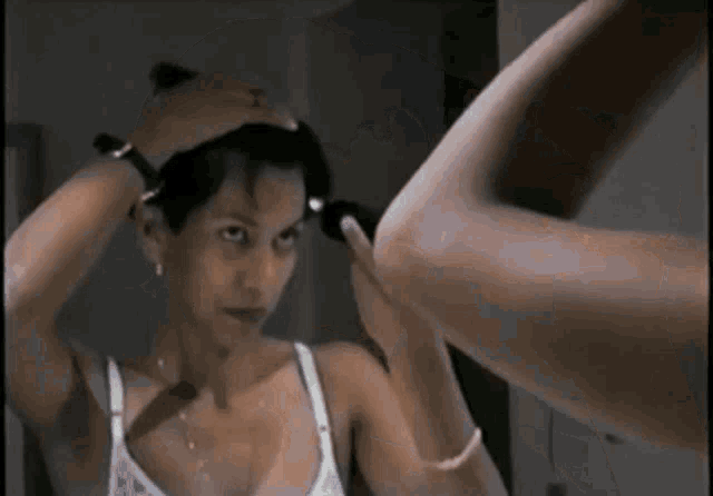 a woman in a bra looks at herself in the mirror
