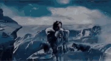 a man is standing on top of a snow covered mountain holding a child .