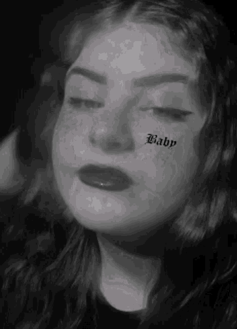a black and white photo of a woman with the word baby on her face