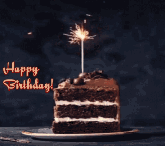 a slice of chocolate cake with a sparkler on top and the words happy birthday on the bottom