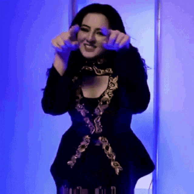 a woman in a black jacket and gold necklace is making a funny face .