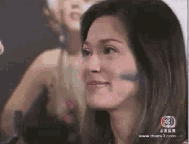 a close up of a woman 's face with the number 3 in the corner