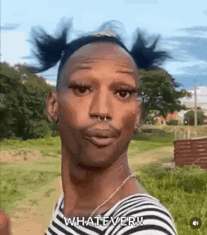 a man with pigtails and a nose ring is standing in a field and making a funny face .