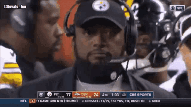 a man wearing a pittsburgh steelers hat talks into a microphone while watching a football game