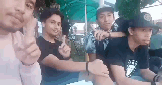 a group of young men are posing for a picture while sitting at a table .