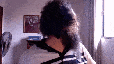 a man with a long beard is standing in front of a window