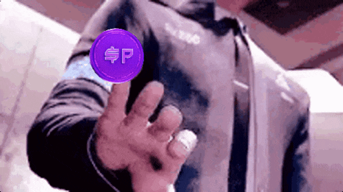 a man in a suit is holding up a purple coin with a dollar sign on it .