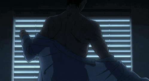 a man without a shirt is looking out a window