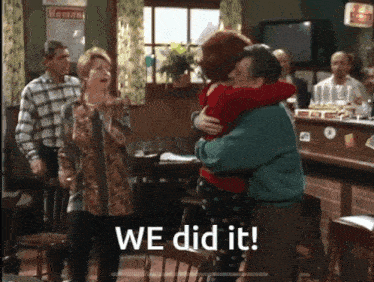 a group of people are hugging in a room with the words we did it on the bottom