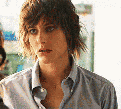 a woman with short hair is wearing a blue shirt