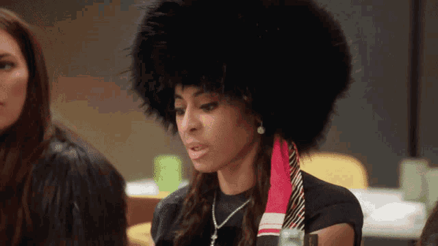 a woman wearing a fur hat and a scarf looks at the camera