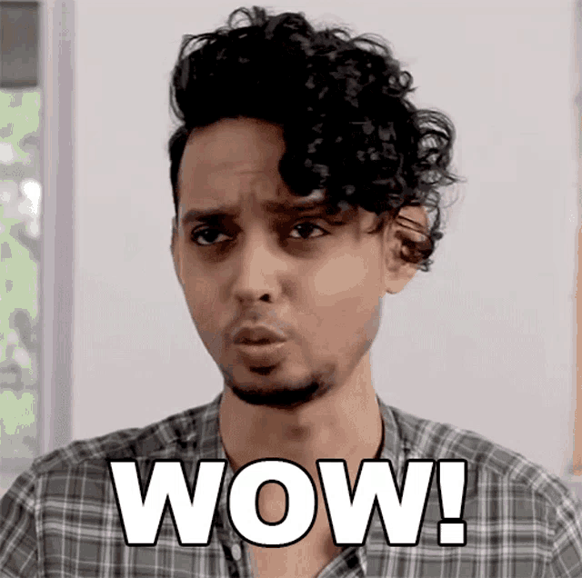 a man with curly hair is making a surprised face and says wow
