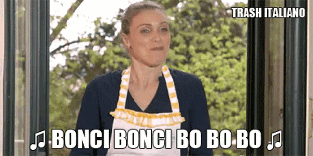 a woman wearing an apron is standing in front of a window and says bonci bonci bo bo bo