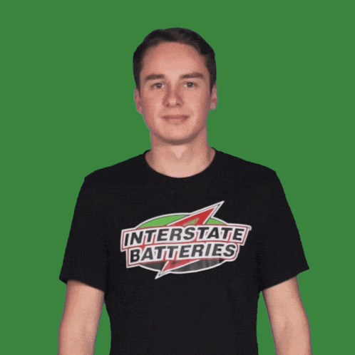 a man wearing an interstate batteries t-shirt is pointing