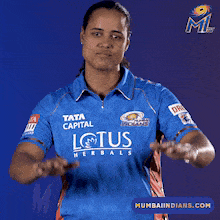 a woman wearing a blue shirt that says lotus herbals