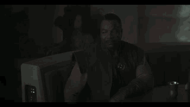 a man in a dark room with the words " all of them " above him