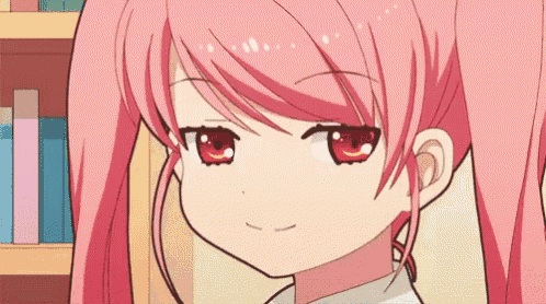 a close up of a pink haired anime girl with red eyes .