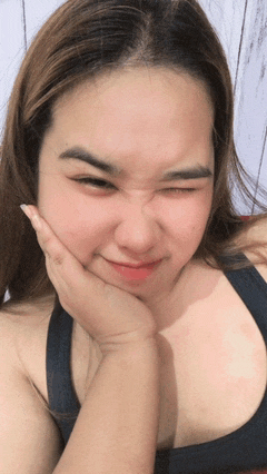 a woman making a face with her hand on her chin