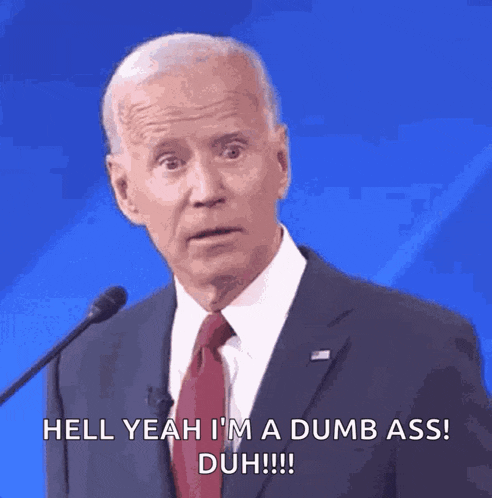 a man in a suit and tie is talking into a microphone and says hell yeah i 'm a dumb ass